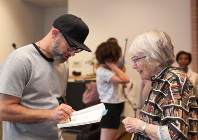 Kevin Coval signs book for Barbara Ballinger