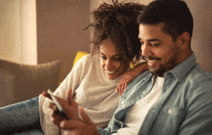 People looking at mobile device on couch
