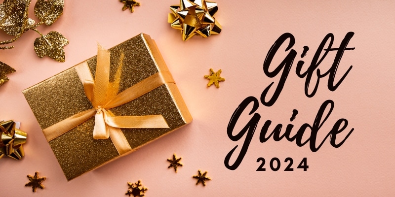 Gift Guide 2024 text with a gold gift box surrounded by gold bows and gold leaves