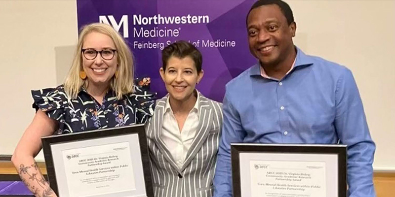 Three people pose in front of a backdrop reading Northwestern Medicine Feinberg School of Medicine. Two hold framed certificates.