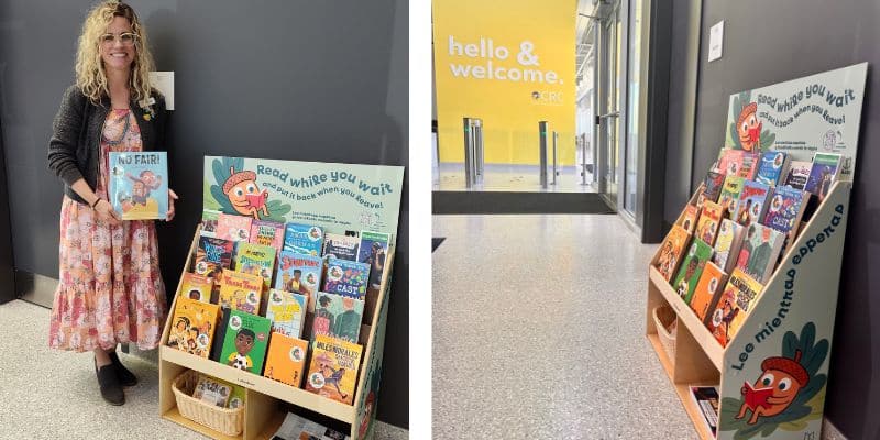 Librarian stands next to bookshelf in a lobby